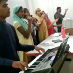 A video still of Sahil helping lead worship at his church.